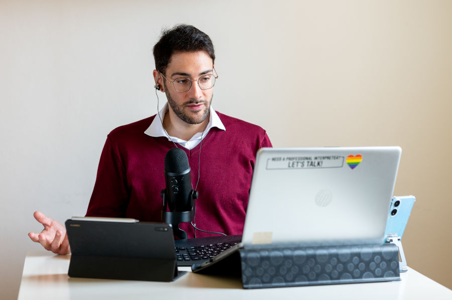 Giacomo Collini, conference interpreter, sitting at his desk and translating simultaneously online